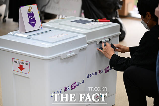 사전투표가 마감된 후 관계자가 관외 투표지 분류를 위해 봉인지를 제거하는 모습.