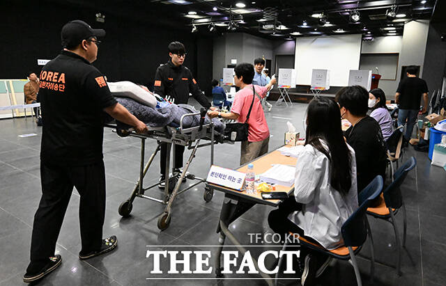 제21대 대통령선거일인 3일 오전 서울 용산구 중부기술교육원에 마련된 한남동 제3투표소에서 한 환자와 보호자가 구급대원의 도움을 받아 투표소에 들어서고 있다. /장윤석 기자