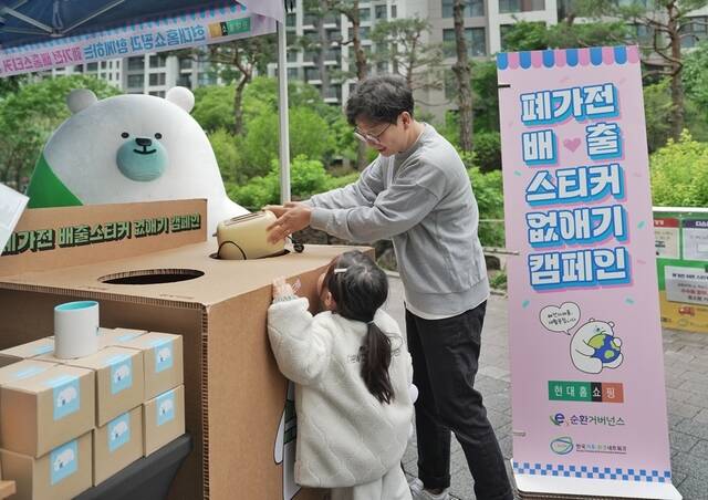 서울 강동구 고라시움아파트에 설치된 현대홈쇼핑의 전자폐기물 자원순환 캠페인 체험 부스를 아파트 주민이 이용하고 있다. /현대홈쇼핑