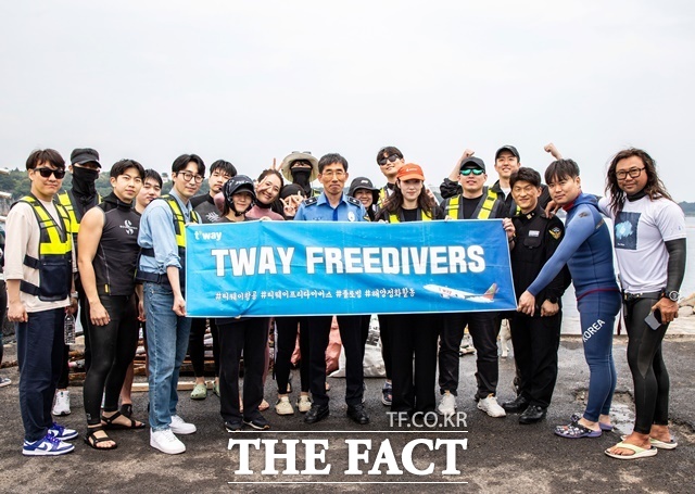 지난달 31일 제주도 서귀포항 해안가에서 진행된 해양 정화 활동 후 티웨이항공 프리다이버스와 박상춘 제주지방해양경찰청장(가운데), 전장원 플로빙코리아 대표(오른쪽에서 첫 번째)가 기념사진을 촬영하고 있다. /티웨이항공
