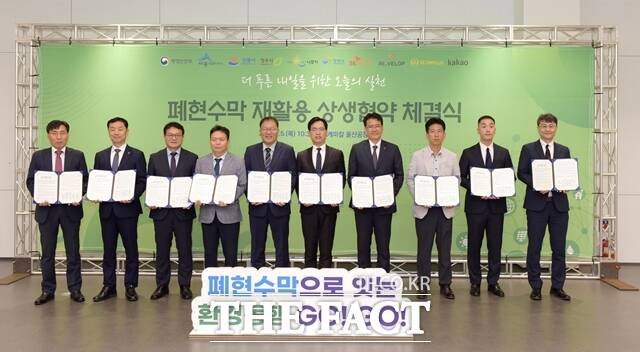 SK케미칼이 5일 울산 남구 SK케미칼 공장에서 5개 지방자치단체, 리벨롭, 세진플러스, 카카오와 함께 지역·기업 상생 발전을 위한 폐현수막 재활용 업무 협약을 체결했다. 김현석 SK케미칼 리사이클사업본부장(오른쪽 네번째), 김민재 행정안전부 차관보(오른쪽 다섯번째) 등이 체결식을 마치고 기념사진을 촬영하고 있다. /SK케미칼