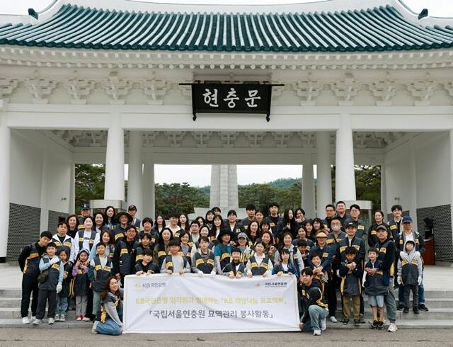 KB국민은행이 호국보훈의 달 및 제70회 현충일을 맞아 국립서울현충원에서 묘역 관리 봉사활동을 실시했다. KB국민은행 임직원과 가족 약 80여 명이 참석해 기념 촬영을 하고 있다. /KB국민은행