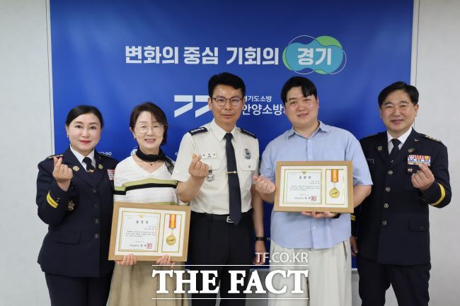 황윤택 사회복지사(오른쪽 2번째)와 최정순 아이돌보미 종사자(4번째)가 장재성 안양소방서장(가운데)으로부터 유공 표창을 받았다. /안양시