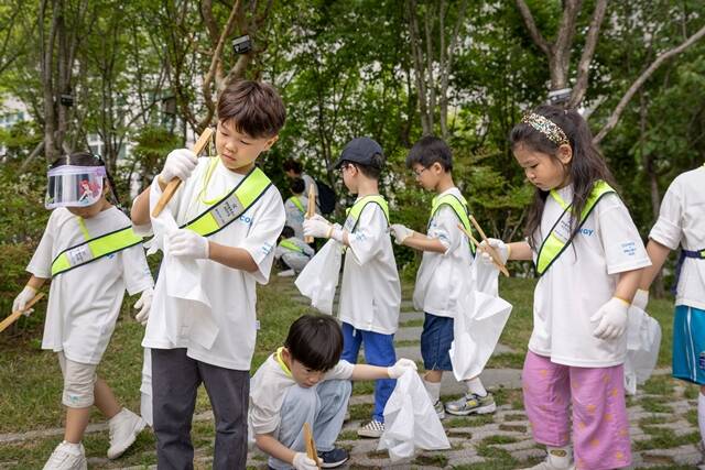 넷마블·코웨이 사내 어린이집 넷마블 푸르니 어린이집의 원생들이 서울 구로구 본사 지타워 내 생태연못 수생비오톱에서 플로깅 활동을 체험하고 있다. /코웨이