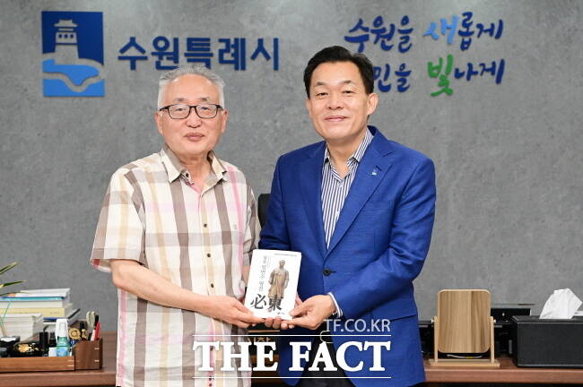 이재준(오른쪽) 수원시장과 박환 고려학술문화재단 이사장이 11일 시청 집무실에서 임면수 선생 평전을 들고 기념 촬영을 하고 있다./수원시