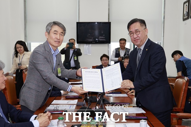 백호 서울교통공사 사장(왼쪽)이 지난달 7일 서울 여의도 국회에서 맹성규 국회 국토교통위원장에게 법정 무임승차 공익서비스 비용에 대한 국비 보전을 촉구하는 공동건의문을 전달하고 있다./서울교통공사