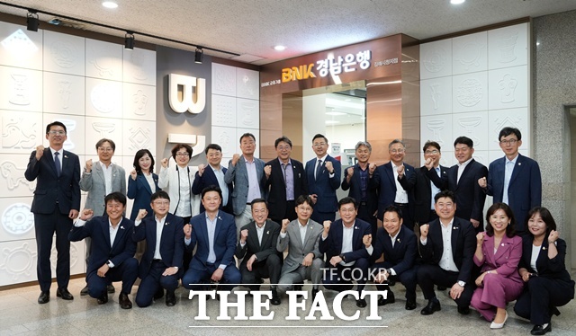 확장 이전한 BNK경남은행 김해시청지점 앞에서 관계자들이 단체 기념촬영을 하고 있다. /BNK경남은행