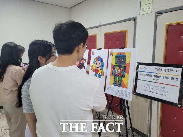 광주시교육청 직원들이 장애학생 인권보호 캐릭터 공모전 시상식에서 선정된 작품을 둘러보고 있다./광주시교육청
