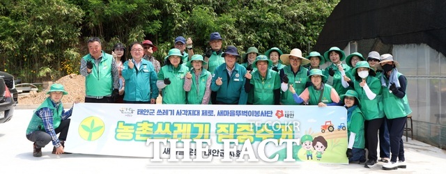 태안군 원북면 신두리의 노인 가구에서 진행된 쓰레기 수거 활동 후 참여자들이 기념 촬영을 하고 있다./ 태안군