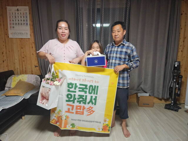 다압면에 거주하는 다문화가정이 결혼기념일을 맞아 축하 선물을 전달받고 기념 촬영을 하고 있다./광양시