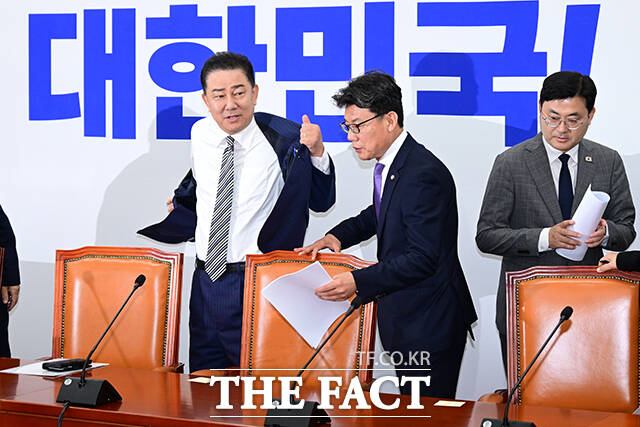 김병기 더불어민주당 대표 직무대행 겸 원내대표(왼쪽)가 17일 오전 서울 여의도 국회에서 열린 원내대책회의에서 발언에 앞서 외투를 벗고 있다. /국회=남윤호 기자