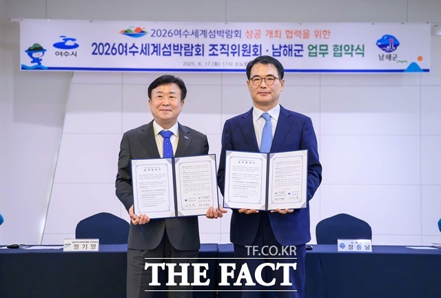 장충남 남해군수(오른쪽)와 정기명 여수시장이 업무협약 후 기념 촬영을 하고 있다./남해군