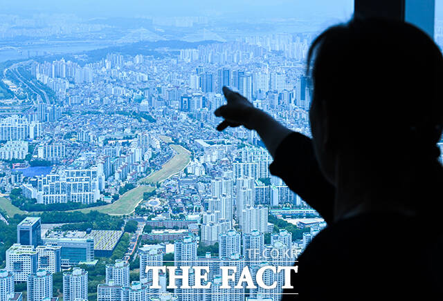 서울 강남 3구(강남·서초·송파) 지역 부동산 가격이 급등한 18일 오후 서울 송파구 롯데월드타워 서울스카이에서 한 시민이 잠실 일대 주택을 바라보고 있다. /장윤석 기자