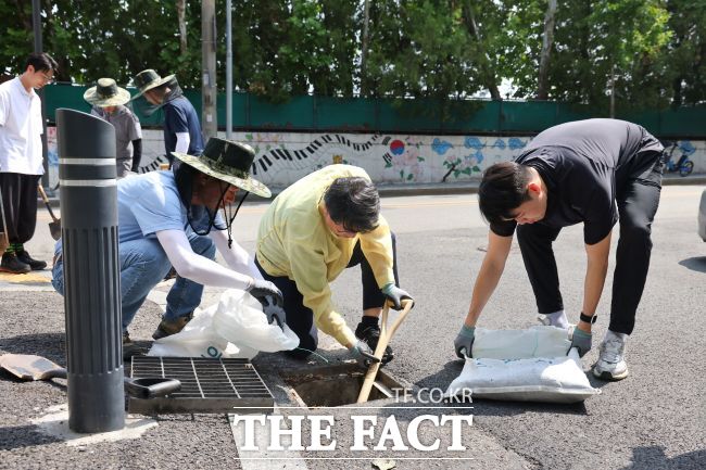 안치권 의왕부시장(가운데)이 도로 빗물받이를 준설하고 있다. /의왕시