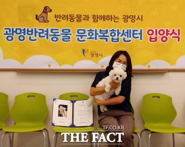 반함 입양식에서 유기견이 새 보호자와 함께 기념사진을 촬영하고 있다. /광명시