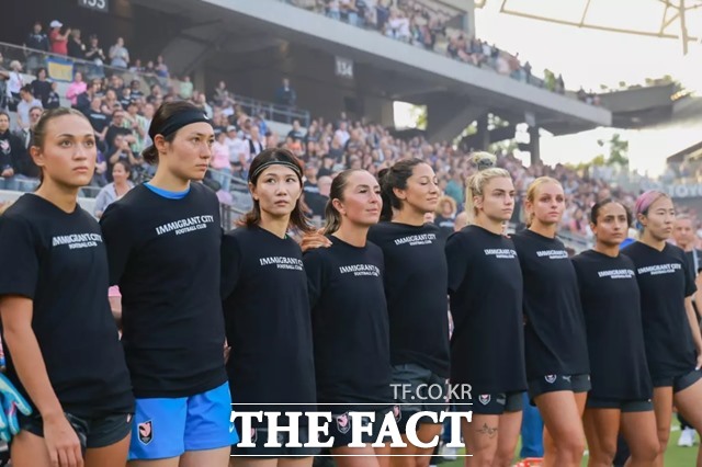 미국 여자프로축구 리그(NWSL) 앤젤시티FC 선수들이 노스캐롤라이나 커리지FC와 경기에 앞서 이민자 도시 축구단(Immigrant City Football Club)이라는 문구의 검은색 티셔츠를 입고 트럼프 정부의 이민자 정책에 반대하는 의사를 표시하고 있다./앤젤시티FC