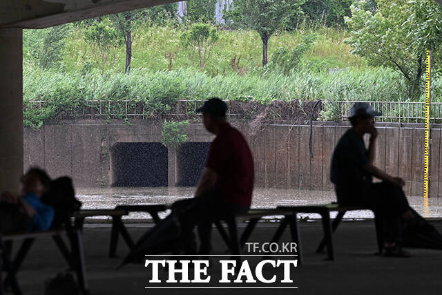 시민들이 양천교 아래에서 비를 피하고 있다.