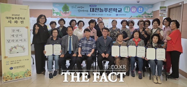 대전평생학습관 2층 로비에서 열린 2025년 대전늘푸른학교 시화전에 참석자들이 김종하 관장과 함께 기념 촬영을 하고 있다. /대전시교육청