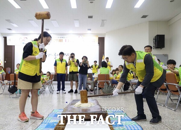 대전 대덕구는 대덕구자원봉사센터와 대덕구 가족봉사단이 21일 구청 청렴관에서 사랑의 인절미 나눔 행사를 개최했다. 사진은 최충규 대덕구청장(사진 오른쪽)과 대덕구 가족봉사단원이 인절미를 만들기 위해 떡메를 치고 있는 모습./대덕구