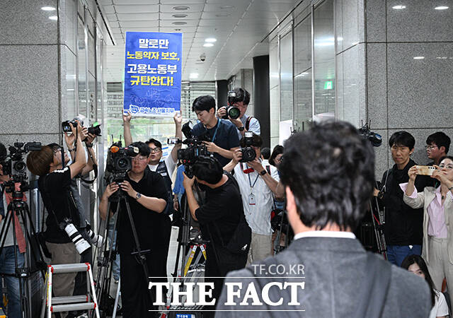 김영훈 고용노동부 장관 후보자가 24일 오후 서울 중구 서울지방고용노동청에 마련된 인사청문회 준비 사무실에 출근하며 취재진의 질문에 답하던 가운데 민주노총 금속노조 주얼리분회 조합원이 김 후보자를 향해 불법사업장에 대한 조사를 해 달라며 피켓을 들고 호소하고 있다. /박헌우 기자
