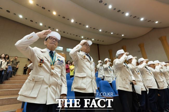 6·25전쟁 발발 75주년인 25일 경기도경제과학진흥원에서 기념식에 참석한 참전용사들이 경례하고 있다. /경기도