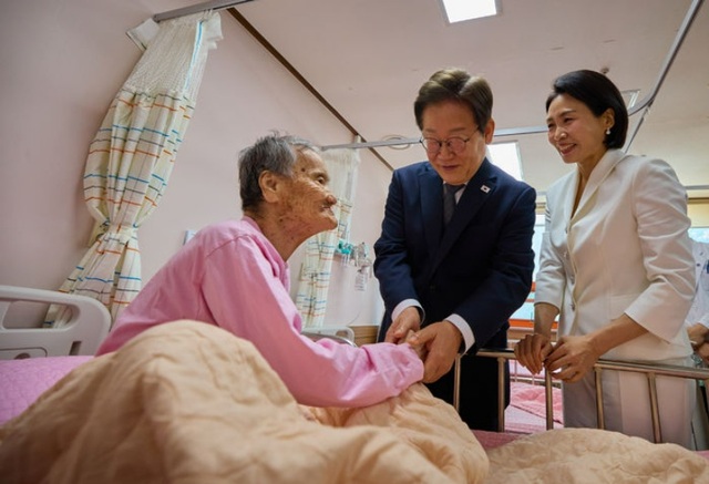 이재명 대통령과 부인 김혜경 여사가 25일 전남 고흥 국립소록도병원을 찾아 환우 어르신의 손을 잡고 위로하고 있다. /대통령실