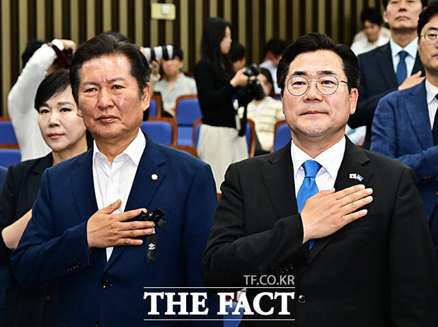 더불어민주당의 차기 당대표가 오는 8월 2일 경기 고양시 킨텍스에서 선출된다. 더불어민주당 당대표 선거에 출마한 박찬대 전 원내대표와 정청래 의원이 24일 오후 서울 여의도 국회에서 열린 의원총회에 참석해 국기에 대한 경례를 하고 있다. /배정한 기자