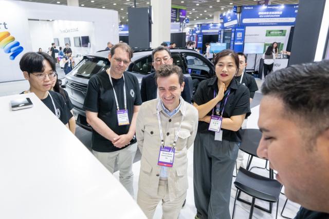 스테판 드블레즈 르노코리아 대표이사 사장과 르노코리아 임직원들이 27일 넥스트라이즈에 마련된 르노 부스를 둘러보고 있다. /르노코리아