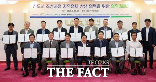 지난달 30일 진행된 지역업체 상생협력을 위한 시·시행자·시공사 간 업무협약(MOU)을 마친 주광덕 경기 남양주시장(앞줄 왼쪽 4번째)을 비롯한 한국토지주택공사(LH) 남양주사업본부장, 경기주택도시공사(GH) 남양주왕숙사업단장, 현대건설을 포함한 13개 시공사 대표 등 관계자들이 협약서를 들어 보이고 있다./남양주시