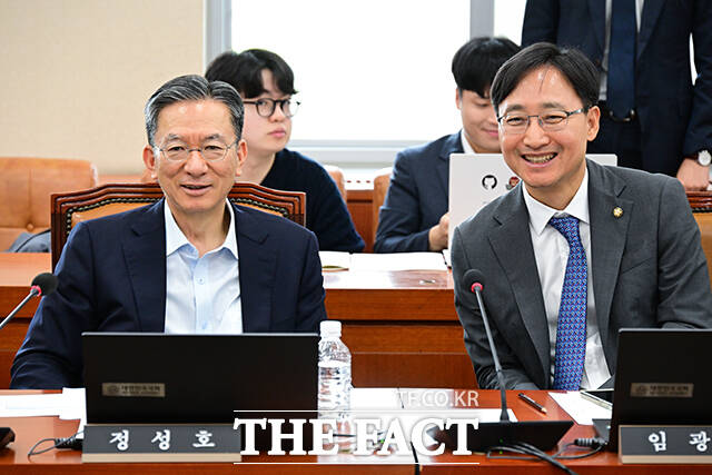 기획재정위원회 전체회의에 참석한 정성호 더불어민주당 의원과 국세청장에 지명된 임광현 더불어민주당 의원이 미소짓고 있다.