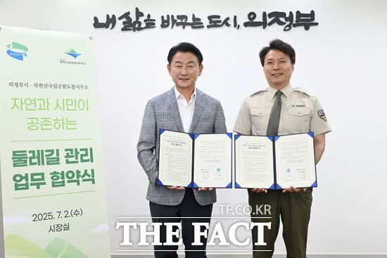 2일 김동근 경기 의정부시장(왼쪽)과 이진범 북한산국립공원 도봉사무소장이 자연과 시민이 공존하는 둘레길 관리 업무협약을 체결한 뒤 협약서를 들어 보이고 있다./의정부시