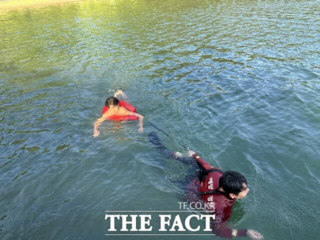 해양경찰관이 무인도에 고립된 A군을 구조하고 있다./통영해경