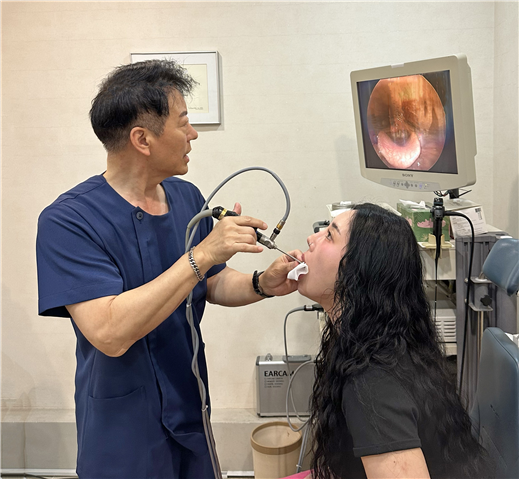 아름다운목소리이비인후과 김영호 원장이 후두내시경으로 환자의 성대를 살피며 진료하고 있다. /아름다운목소리이비인후과