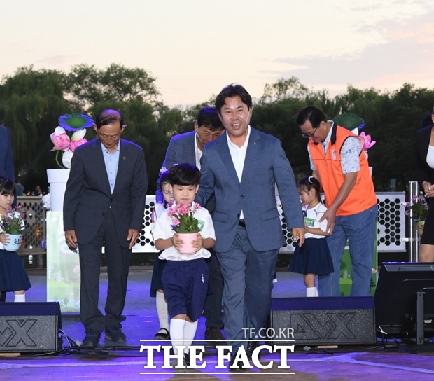 박정현 부여군수가 지난 4일 궁남지에서 열린 역사문화 정원도시 부여 비전 선포식에서 퍼포먼스를 마치고 어린이와 함께 나오고 있다. /김형중 기자