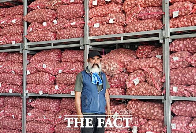 염만규 공주유황꽃마늘생산자협의회장이 수확한 마늘 앞에서 효능을 설명하고 있다. /김형중 기자