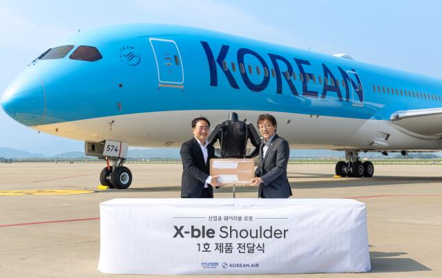 현대자동차∙기아 로보틱스랩 현동진 상무(왼쪽)와 대한항공 항공우주사업본부 정현보 상무가 지난 8일 인천 중구 대한항공 항공기 정비고에서 엑스블 숄더 1호 전달식 후 기념사진을 촬영하는 모습. /현대차그룹