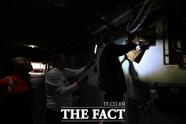 갑자기 나간 전기에 주민들이 조명을 비추면서 수리를 하고 있다.