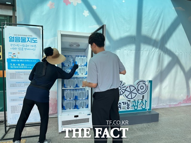 시민이 얼음물 나눔 냉동고에서 얼음 생수를 꺼내고 있다./광주 광산구