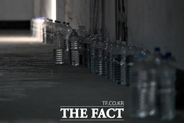 문 앞에 물이 담긴 페트병이 줄지어 놓여있다. 고양이를 내쫓기 위함이다.