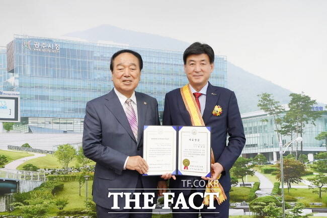 방세환(오른쪽) 광주시장이 11일 시청을 방문한 신경택 세계자유민주연맹 경기도지부 회장으로부터 자유장을 받은 뒤 기념 촬영을 하고 있다./광주시