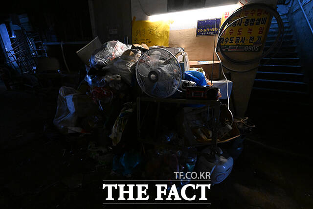 쓰레기와 가전제품이 한데 뒤섞인 가운데 라디오에서 음악이 나오고 있다.