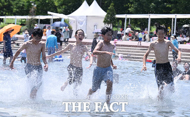 서울 낮 최고기온이 36도까지 오른 12일 오후 서울 여의도 한강공원 물빛광장을 찾은 학생들이 물놀이를 하며 더위를 식히고 있다. /이새롬 기자