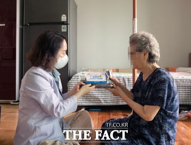 방문간호사가 건강 취약계층 노인에게 폭염 대비 물품을 배부하고 있다./시흥시