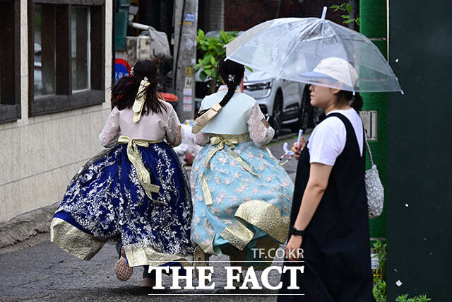 13일 오후 서울 종로구 창성동 거리에서 한복을 입고 관광을 즐기던 외국인들이 떨어지는 빗방울에 거리를 달리고 있다. /남윤호 기자