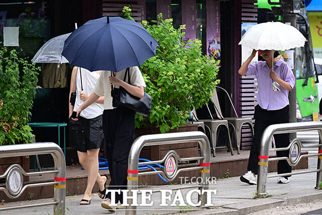 화요일인 15일은 전국이 대체로 흐리고 비가 내리겠다. 비가 내리면서 찜통더위는 주춤할 것으로 보인다. 사진은 지난 13일 오후 서울 종로구 창성동 거리에서 시민들이 우산을 쓴 채 걸음을 옮기고 있는 모습./남윤호 기자