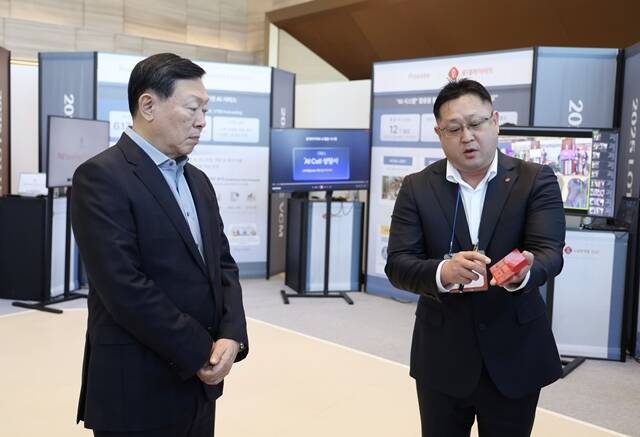 신동빈 롯데그룹 회장(왼쪽)이 지난 1월 서울 송파구 롯데월드타워에서 열린 2025 상반기 VCM에 참석하기 전 AI 과제 쇼케이스를 살펴보며 롯데케미칼의 AI 기반 컬러 예측 시스템에 대한 설명을 듣고 있다. /롯데그룹
