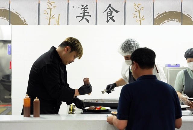 지난 11일 경기 화성시 원익IPS 구내식당에서 CJ프레시웨이 더 미식 테이블 캠페인에 참여한 윤남노 셰프가 특식을 배식하고 있다. /CJ프레시웨이