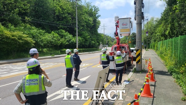 한전주 위의 발판에 올라 작업하는 모습을 지켜보고 있는 박상형 한전KDN 사장(오른쪽 두번째). /한전KDN