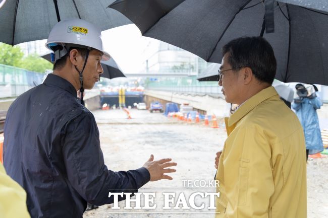 김동연 경기도지사가 16일 오후 수원 화산지하차도 공사 현장에서 공사 관계자에게 강우 대비 사전 점검 사항을 보고받고 있다./경기도