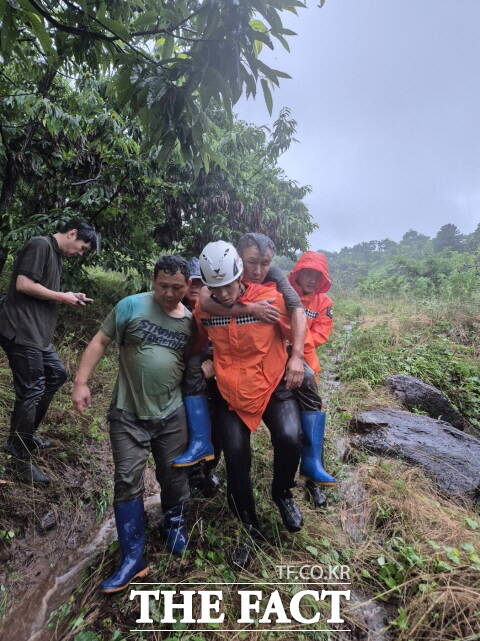 17일 오전 충남 공주시 정안면에서 집중호우로 인한 토사 유출 사고가 발생해 작업자 4명이 매몰되자 출동한 공주소방서 직원이 매몰자를 구해내고 있다. /공주소방서